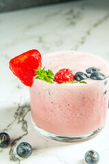 Mound of fresh blueberries and a blueberry and hemp protein smoothie on a cedar wood surface