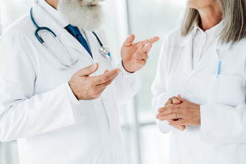 Playful professional doctors discuss patient care in clinic during a friendly medical consultation scene