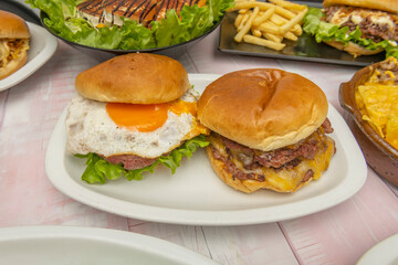 Still life with a fish burger, potatoes with skin, and sliced ​​lemon on a fishnet background