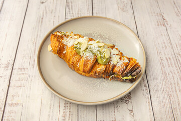 Open croissant with homemade pâté de campagne, pickled gherkins, and truffle butter on laminated dough
