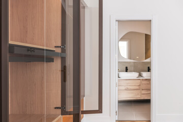 Attic with custom built-in wardrobes, reclaimed wood shelving, and minimalist Scandinavian-design pendant lights
