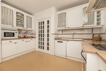 Modern kitchen with glossy white finishes, built-in appliances, and an extractor fan system