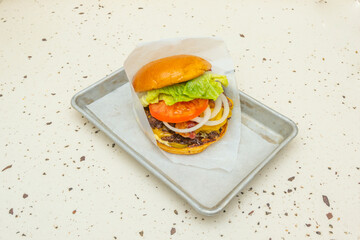 Premium burger with certified Angus beef, melted Appenzeller cheese, thickly sliced ​​tomato, and lettuce on a brioche bun