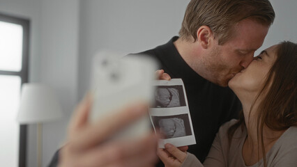 Man and woman joyously taking selfie with ultrasound photo in bright home showcasing pregnancy...