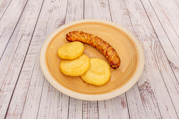 Sausage rolls in puff pastry with yellow cheese, baked until golden brown and served with homemade spicy tomato sauce