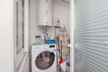 Service room complete with a washing machine, a separate dryer, and a boiler, all in a small but...