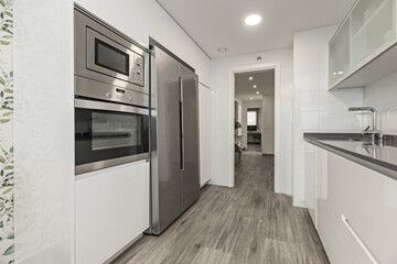 Contemporary kitchen with navy blue cabinets, white quartz countertops, and wood-effect porcelain flooring