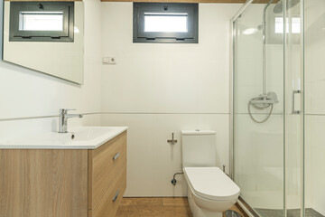 Wooden wall-mounted vanity unit with drawers in a small bathroom, combining natural warmth and clean lines for a contemporary look