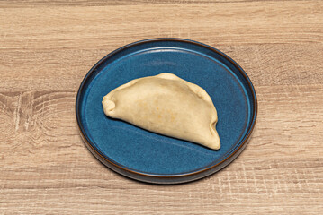 Sobrasada and honey empanadas, golden and crispy dough, sprinkled with powdered sugar and accompanied by fresh cheese