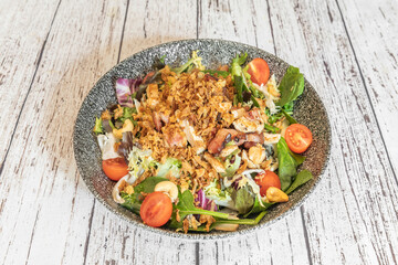 A Greek-inspired salad with diced tomatoes, half-moon red onions, and iceberg lettuce, tossed with Kalamata olive oil