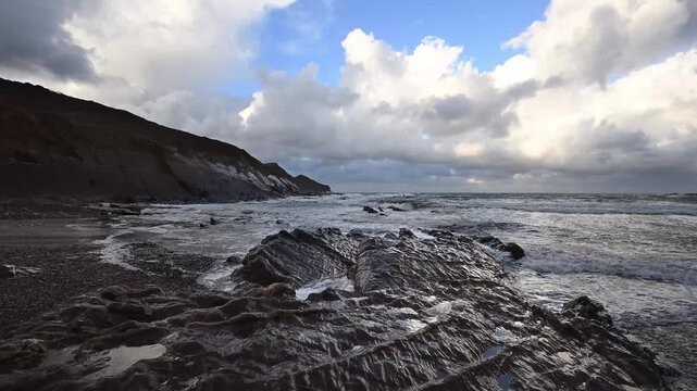 Storm clouds open to let the sun through at Crackington Haven beach Cornwall