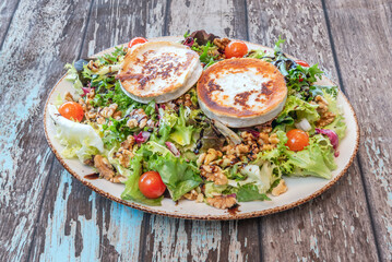 Gourmet salad with honey-caramelized goat cheese roll, accompanied by poached pears, walnuts, and alfalfa sprouts