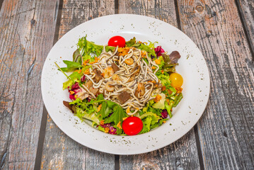 Arugula and lamb's lettuce salad with canned tuna, pomegranate, walnuts, and crumbled feta cheese, dressed with raspberry vinaigrette