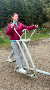 Woman exercising on a fitness machine outdoors