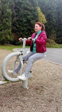 Woman exercising on a fitness machine outdoors
