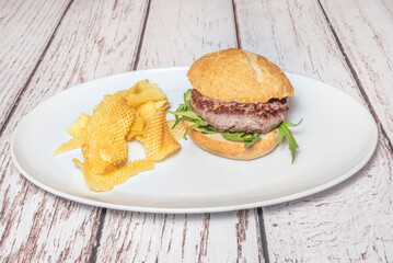 Burger with a black brioche bun, beef, melted white cheese, and strips of bacon, creating an elegant monochromatic look.