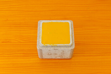 Mango ice cream tub with tropical fruit chunks, passion fruit sauce, and shredded coconut,