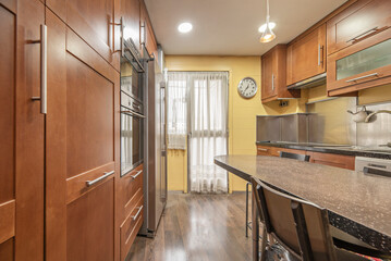 Modern kitchen with a solid wood island, built-in induction cooktop, and a minimalist extractor hood