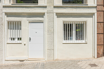 Loft apartment in a converted commercial ground floor with an antique oak door and a metal awning marking the street access