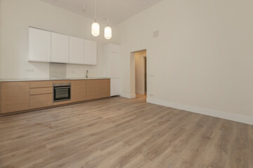 Modern kitchen design with natural oak wood paneling, under-cabinet lighting, and directional spotlights in the ceiling