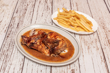 Greek-style roasted chicken with lemon and oregano, accompanied by fries with crumbled feta cheese and olives