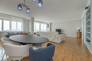 Family dining room with a large dark wood table and high-backed chairs upholstered in beige fabric, cozy and functional