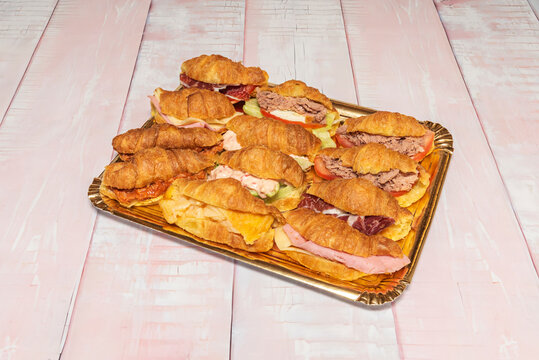 Mini puff pastry croissants filled with curry-flavored shredded chicken and raisins, sprinkled with chopped fresh chives and paprika