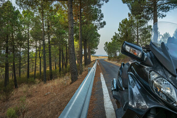A maxi-scooter with a handlebar-mounted navigation system, stopped in a wide arc while capturing...