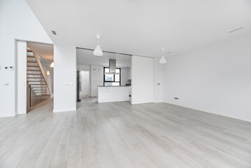 Open-plan basement space with a central access staircase and exposed structural pillars, perfect for dividing into rooms.