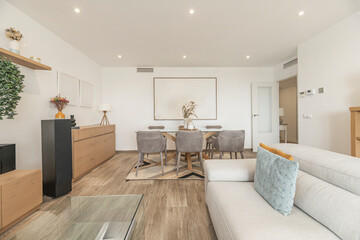 Warm atmosphere with linen sofa, solid wood coffee table, and dining room with wicker bench and chairs