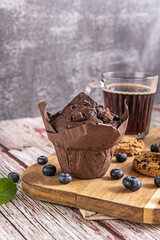 A fun dessert image with cookies decorated with icing, a blueberry smoothie served in a lidded jar, and scattered blueberries on a cheerful, light purple background