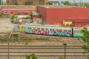Twin commuter rail tracks crossing a level crossing with lowered barriers and flashing red lights.