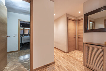 Hallway where sunset light filters through an exterior lattice, painting the white walls with golden tones