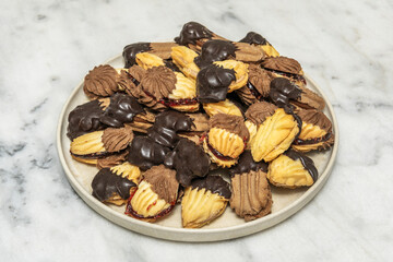 A surreal arrangement of floating tea pastries on a black background, highlighting the textures of shortbread, gingerbread, and flaky palm trees