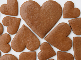 Undecorated heart-shaped gingerbread cookies in three sizes on a white background