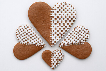 Decorated heart-shaped gingerbread cookies in three sizes on a white background