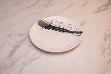 Ceramic plate with spattered glaze, a  unpredictable effects of color and texture