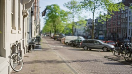 Blurred amsterdam cityscape featuring bicycles, cars, and trees along a sunlit street with...