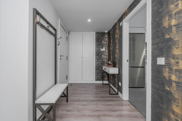 A narrow, unadorned corridor lit by aligned recessed spotlights that create a modern and functional geometric rhythm