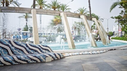 Mosaic tiled bench and curving fountain rendered soft and defocused in an outdoor plaza background with palms and water spray; background backplate copyspace template.