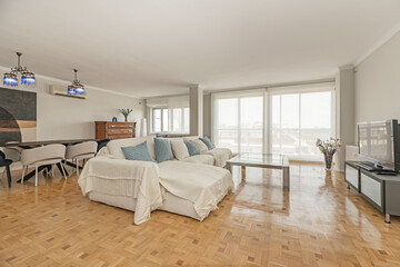 Cozy atmosphere with an L-shaped sofa, a jute rug, a rustic dining table, and built-in shelves