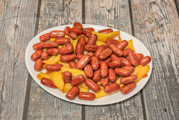 Venezuelan-style hot dogs with ranchera sausage, shredded cabbage, French fries, and multiple sauces on soft bread
