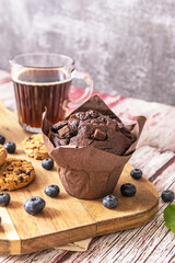 A perfect snack: a blueberry and berry smoothie bowl with toppings, chocolate chip cookies with dried cranberries, and fresh fruit on a soft lilac background