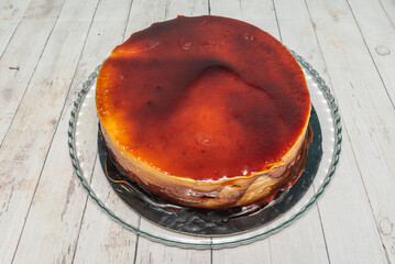 Classic caramel tart with a creamy dulce de leche texture, decorated with thin chocolate flakes and...