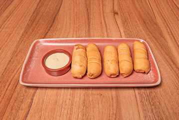 Comparison between baked and fried tequeños, showing the differences in texture and color while both maintain their characteristic shape