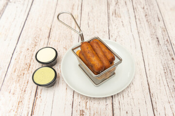 Stainless steel basket with perfectly rolled golden , served warm with creamy guacamole and homemade hot sauce