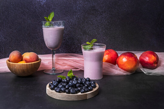 Freshly washed blueberries and a blueberry and kale smoothie on a naturally oiled pine wood table