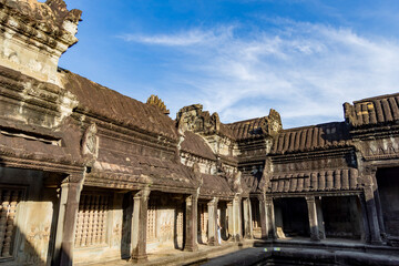 Morning light on stone galleries and roof pediments of the angkor wat cloister in siem reap, cambodia, showing khmer architecture details and weathered sandstone