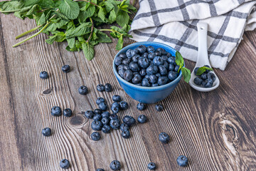 Patriot blueberries on a black slate background and a satin-finished stainless steel spoon