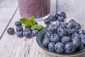 Still life with blueberries and a blueberry and natural yogurt smoothie on a European walnut table